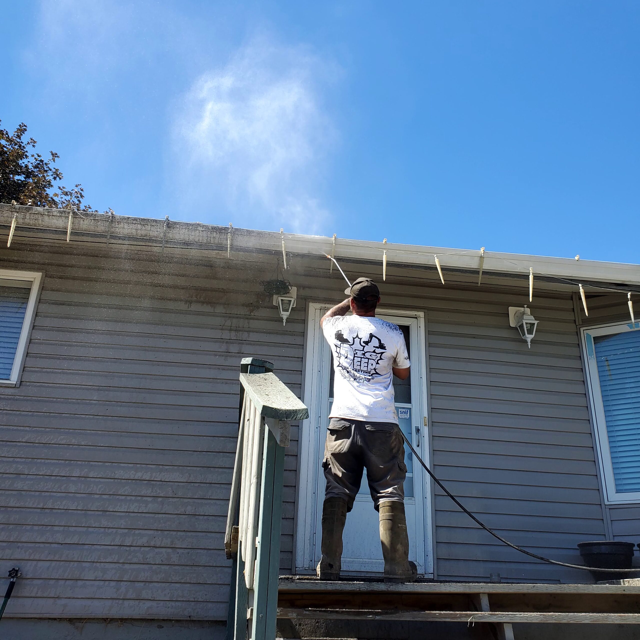 Power washing a house in Westsyde